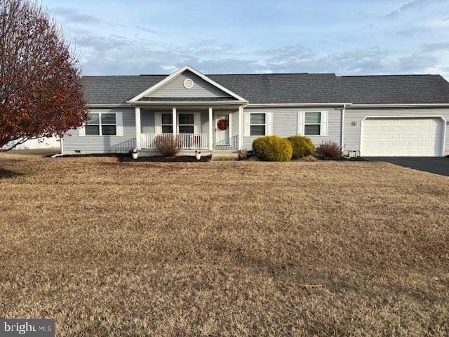 single story home featuring covered porch, a garage, and a front yard