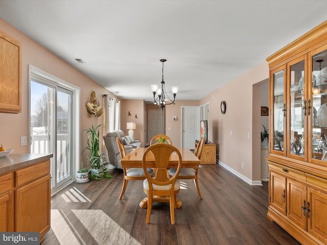 dining area featuring dark hardwood / wood-style floors and a notable chandelier