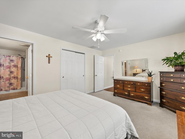 bedroom with light carpet, a closet, ceiling fan, and ensuite bathroom