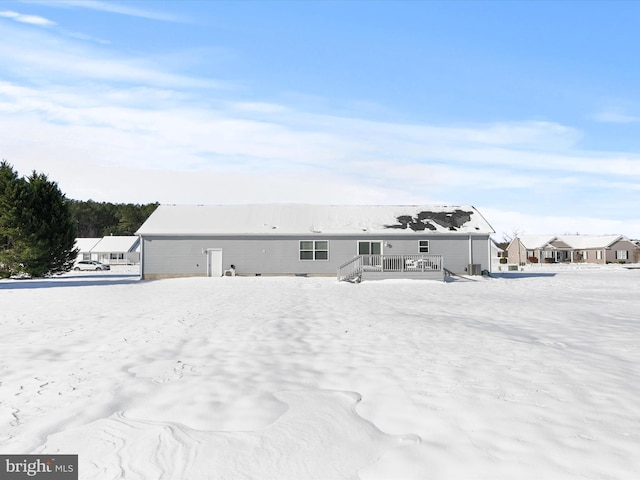 snow covered rear of property featuring a deck