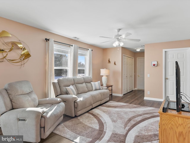 living room featuring ceiling fan and dark hardwood / wood-style floors