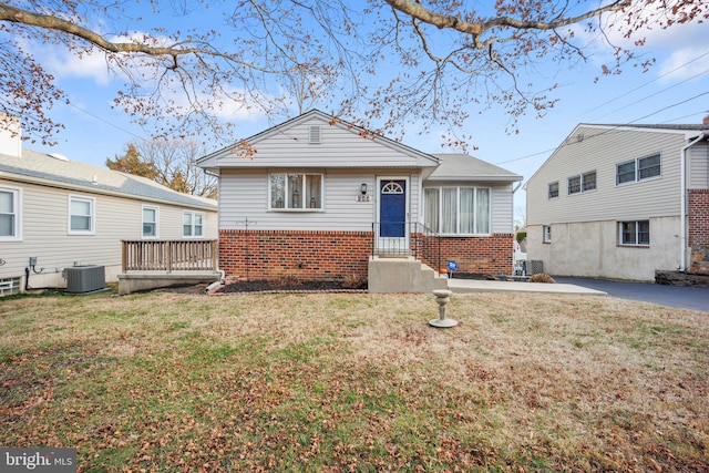 bungalow with a front lawn and cooling unit