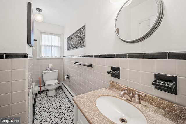 bathroom with vanity, toilet, tile walls, and a baseboard radiator