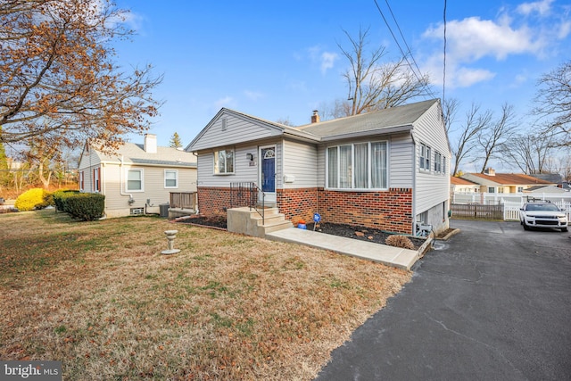 bungalow-style home featuring a front lawn and central AC unit