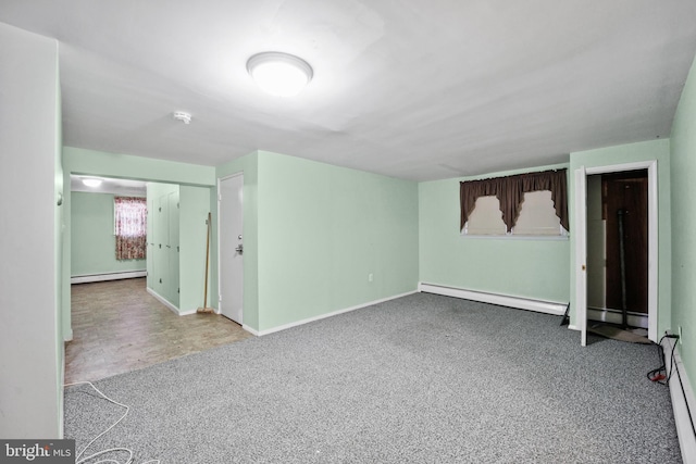 unfurnished room featuring carpet floors and a baseboard heating unit