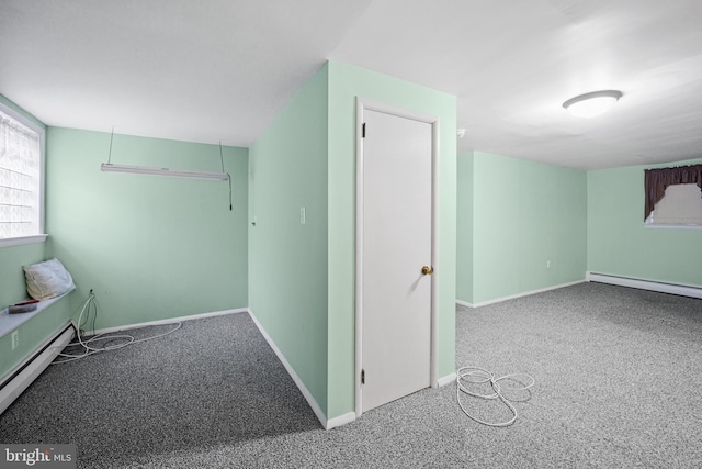 additional living space with carpet flooring and a baseboard heating unit