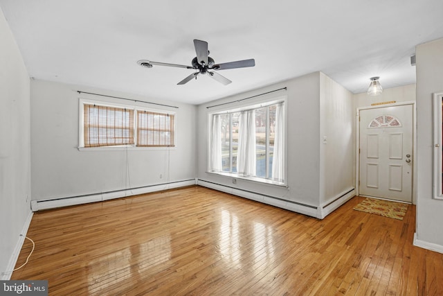 unfurnished room featuring ceiling fan, light wood-type flooring, and a baseboard radiator