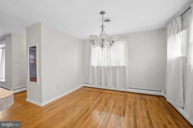 unfurnished dining area featuring light hardwood / wood-style flooring, an inviting chandelier, and a baseboard heating unit