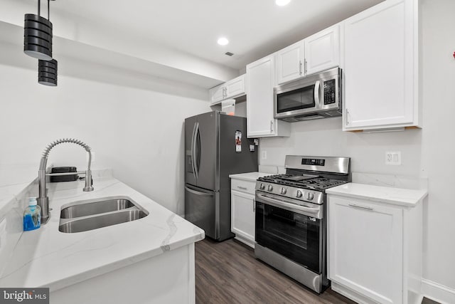 kitchen with light stone counters, sink, stainless steel appliances, and white cabinets