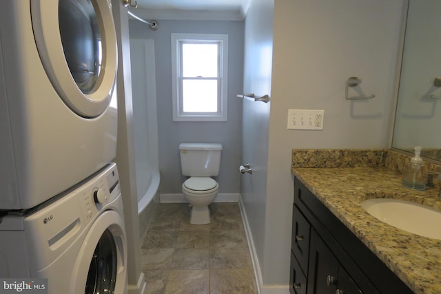 bathroom with vanity, toilet, and stacked washer / dryer