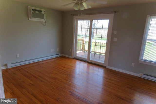 empty room with baseboard heating, ceiling fan, hardwood / wood-style floors, and an AC wall unit