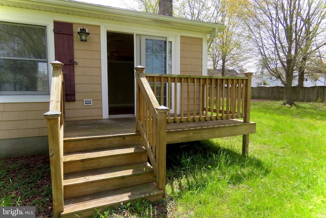 entrance to property with a lawn and a wooden deck