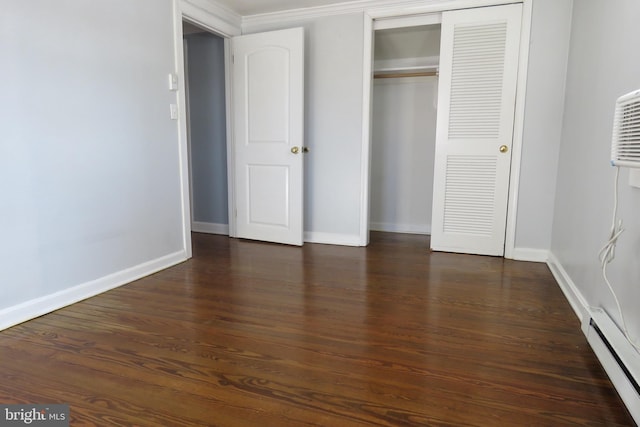 unfurnished bedroom featuring dark hardwood / wood-style floors, baseboard heating, and ornamental molding