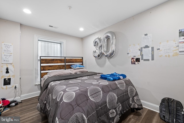 bedroom with dark hardwood / wood-style flooring