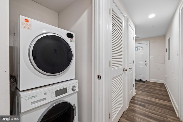 laundry area with dark hardwood / wood-style flooring and stacked washer and clothes dryer