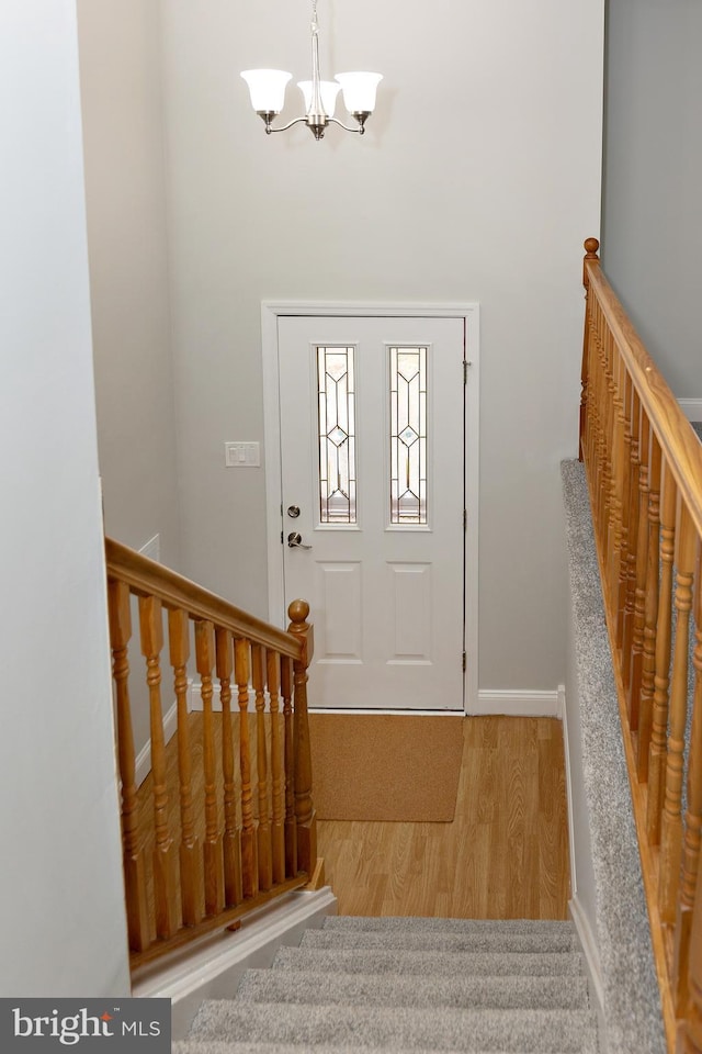 foyer entrance with light hardwood / wood-style floors and a chandelier