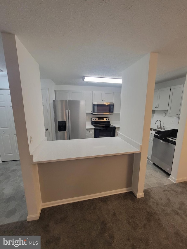 kitchen featuring stainless steel appliances, light colored carpet, light countertops, and white cabinetry