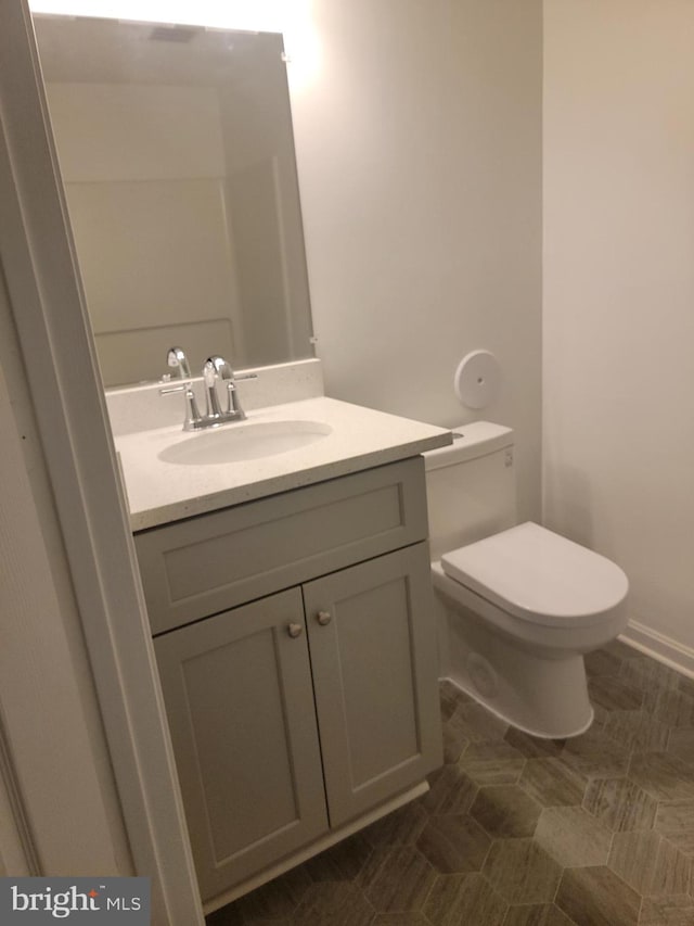 half bathroom with vanity and toilet