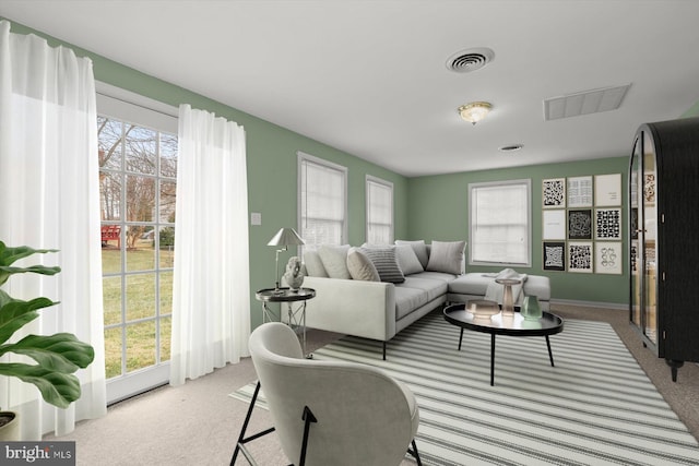 living area with carpet floors, plenty of natural light, and visible vents