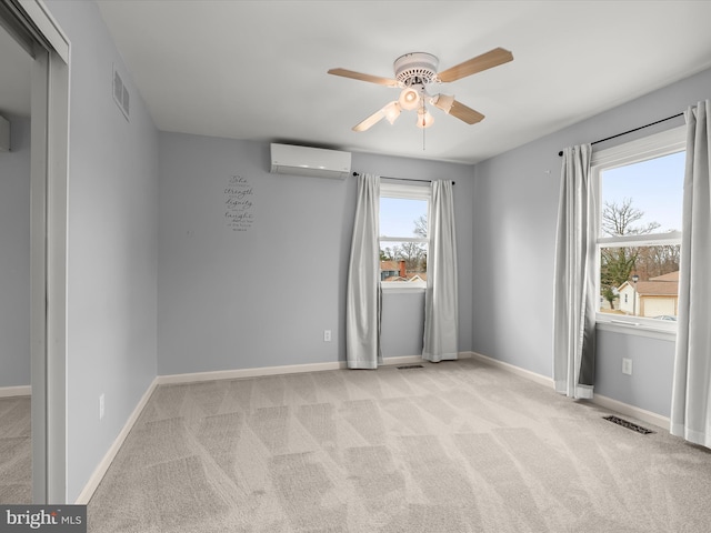 spare room with carpet, a wall mounted air conditioner, visible vents, and baseboards