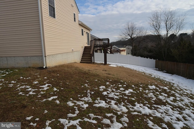 yard covered in snow featuring a deck