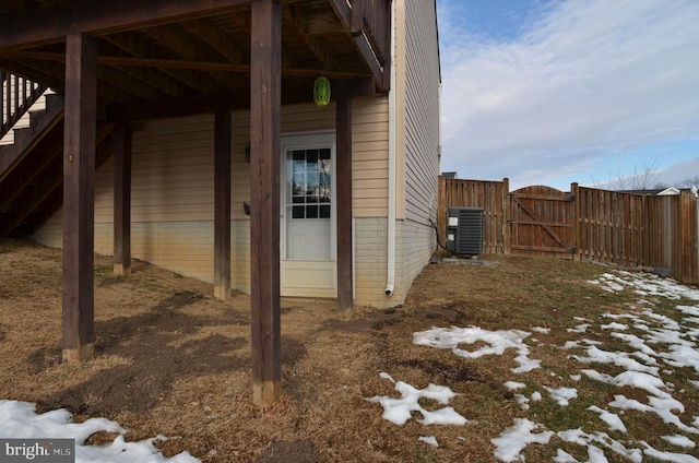 snow covered property entrance featuring central AC