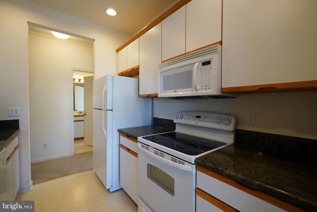 kitchen with white cabinetry, light colored carpet, and white appliances