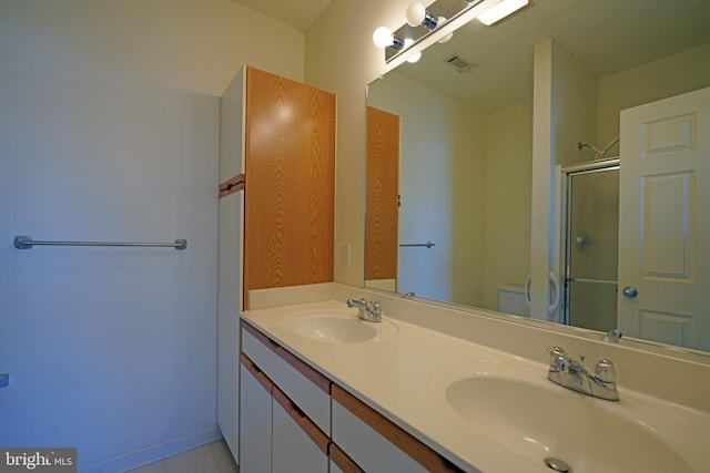 bathroom featuring tile patterned floors, vanity, toilet, and a shower with door