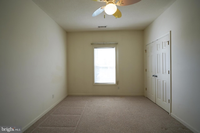 unfurnished room featuring light colored carpet and ceiling fan