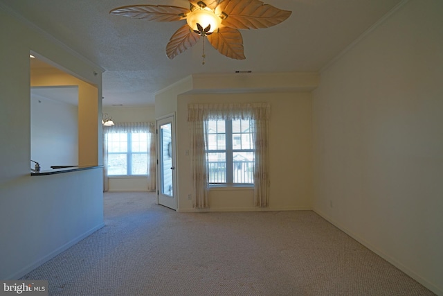 spare room featuring light carpet, ceiling fan with notable chandelier, a textured ceiling, and ornamental molding