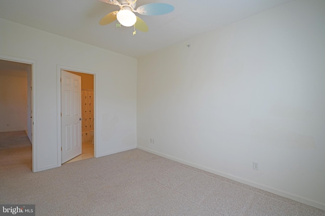 unfurnished bedroom with ceiling fan, light colored carpet, and ensuite bath