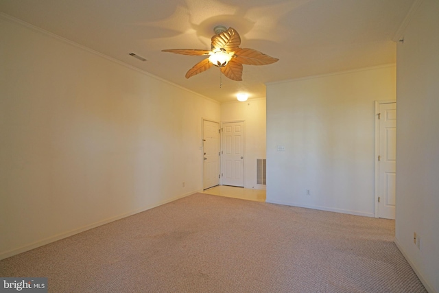 carpeted empty room featuring crown molding and ceiling fan