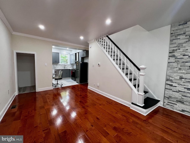 unfurnished living room featuring ornamental molding and hardwood / wood-style flooring