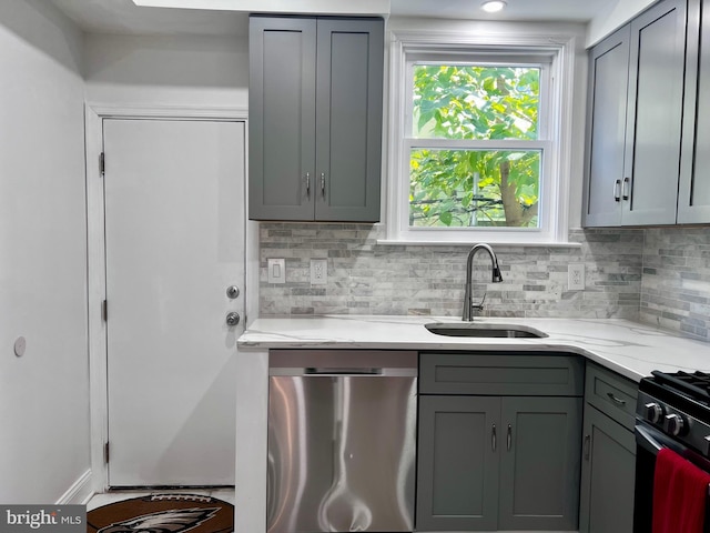 kitchen featuring tasteful backsplash, gray cabinetry, sink, and stainless steel appliances