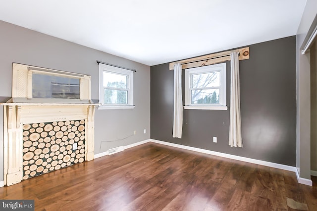 unfurnished room featuring dark hardwood / wood-style floors and a wealth of natural light