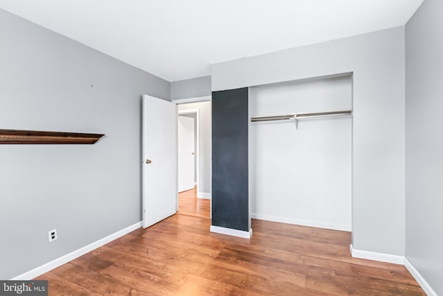 unfurnished bedroom featuring hardwood / wood-style floors and a closet