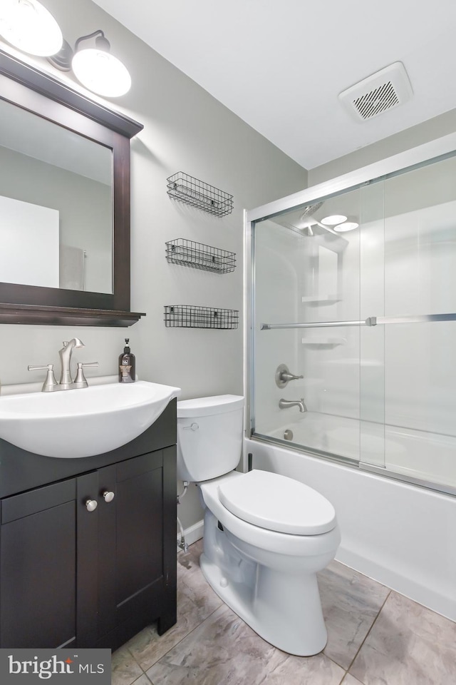 full bathroom featuring vanity, toilet, and bath / shower combo with glass door