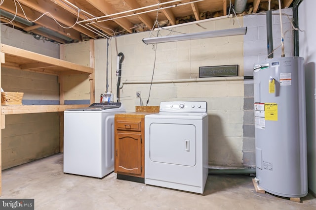 washroom featuring water heater, cabinets, and independent washer and dryer