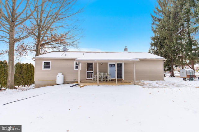 view of snow covered back of property