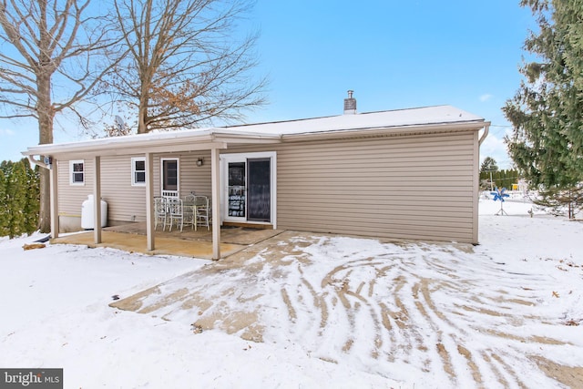 view of snow covered rear of property