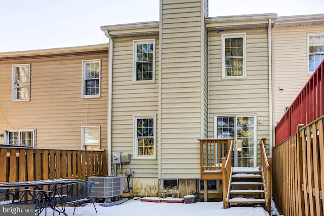 snow covered back of property with central air condition unit