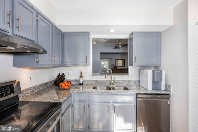 kitchen with sink, stainless steel appliances, and light stone countertops