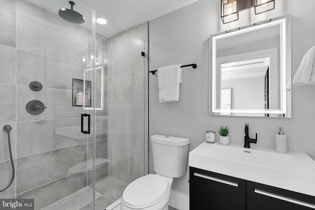 bathroom with toilet, walk in shower, and vanity