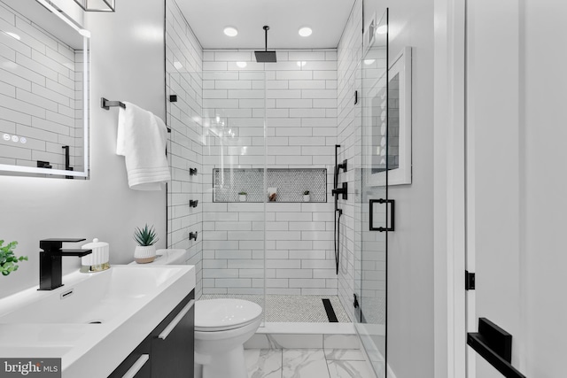 bathroom featuring a shower with door, toilet, and vanity