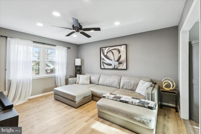 living room with ceiling fan and light wood-type flooring