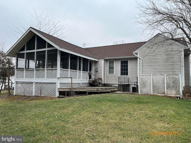 rear view of house featuring a sunroom and a yard