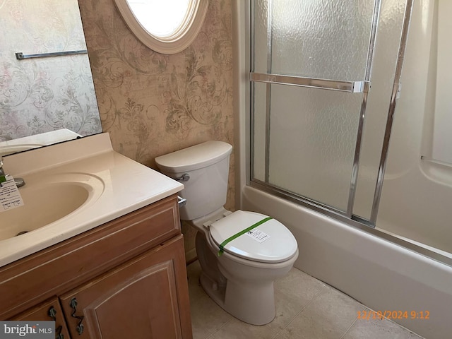 full bathroom featuring vanity, bath / shower combo with glass door, and toilet