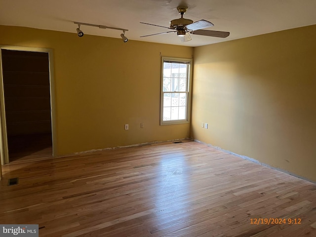 unfurnished room with ceiling fan, light hardwood / wood-style flooring, and track lighting