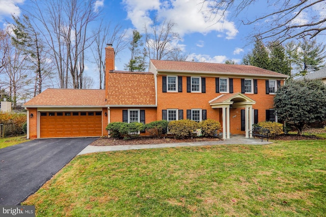 colonial home with a front lawn and a garage