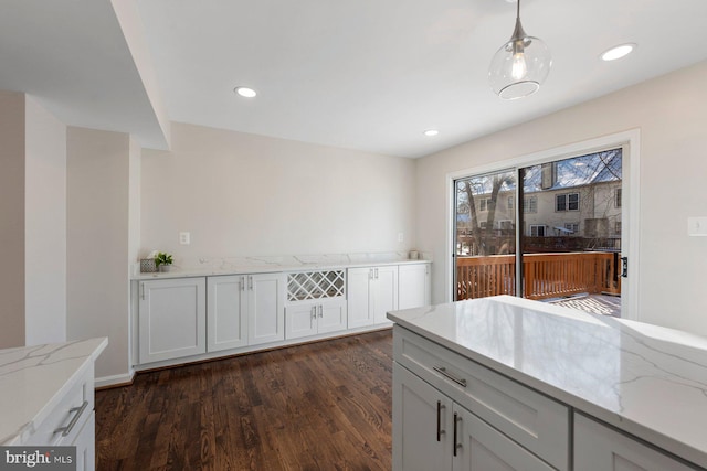 kitchen featuring white cabinets, dark hardwood / wood-style floors, and light stone countertops